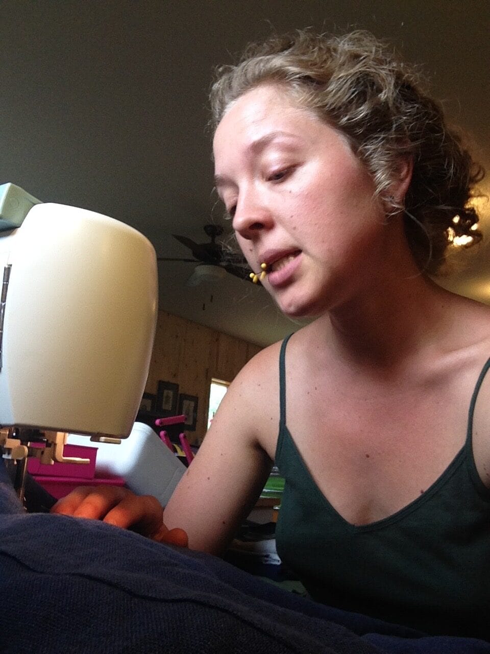 a caucasian woman sewing and singing with pins in her mouth, Margareta in About Maxon Made