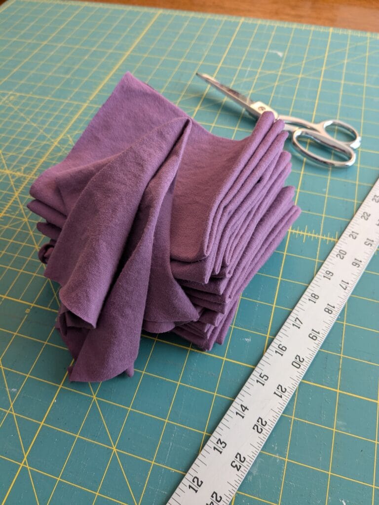 DIY hankies in a pile with a scissors and a ruler on a cutting mat