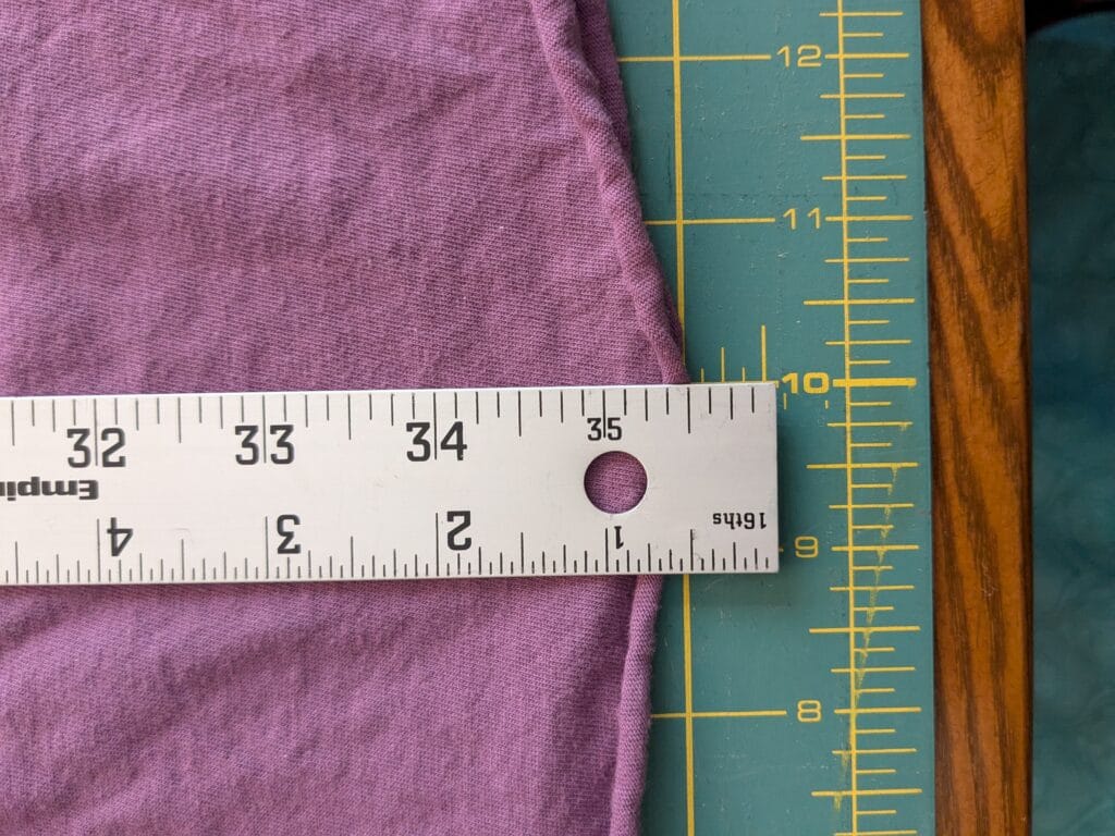 a ruler laying on a piece of fabric on a cutting mat