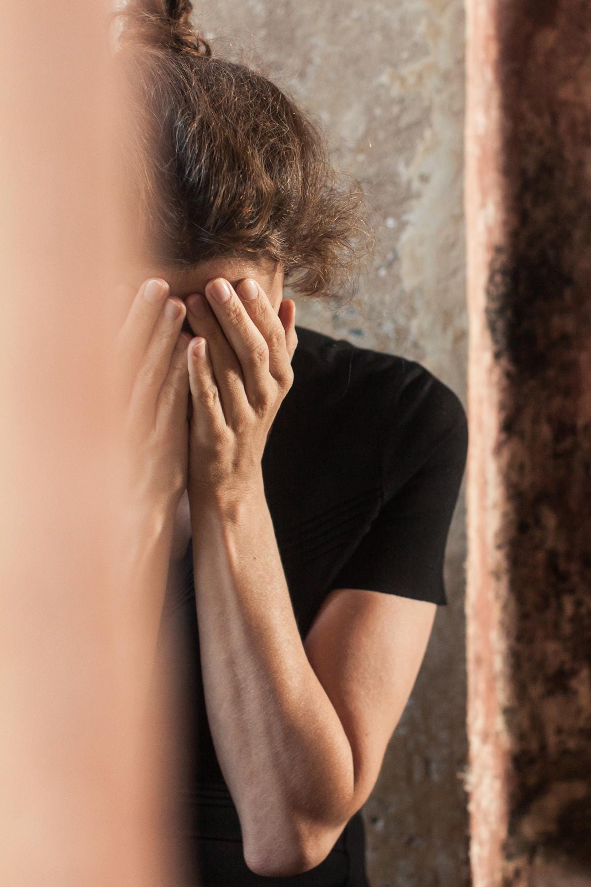 A picture of us peeking through the doorway at a woman with her face in her hands, grieving and coping with multiple miscarriages, trying to decide when she should try to let her baby go.