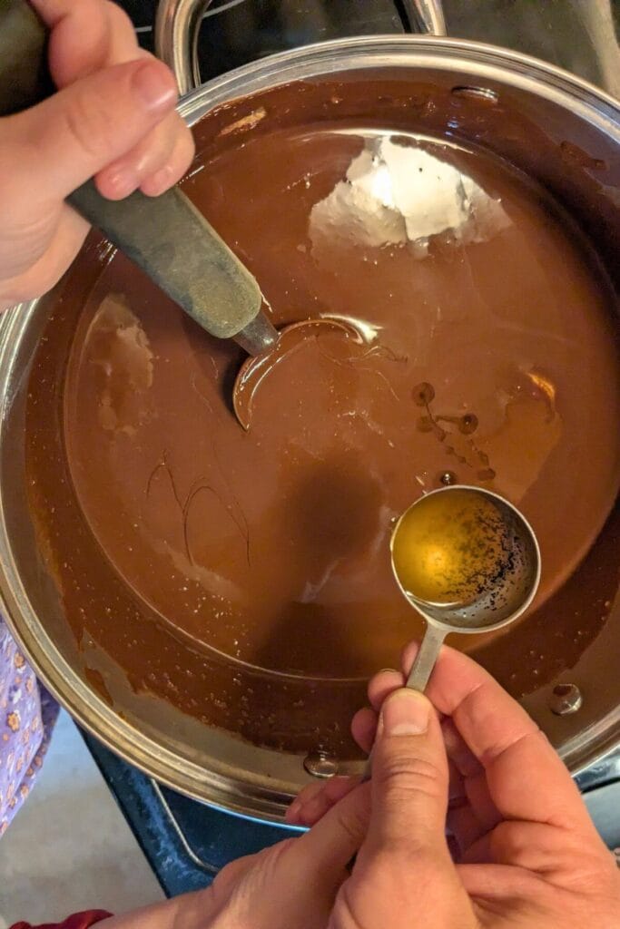 adding homemade vanilla extract to Ghirardelli 72% dark chocolate chips, Kerrygold pastured butter, and one full jar of organic peanut butter melted in a saucepan