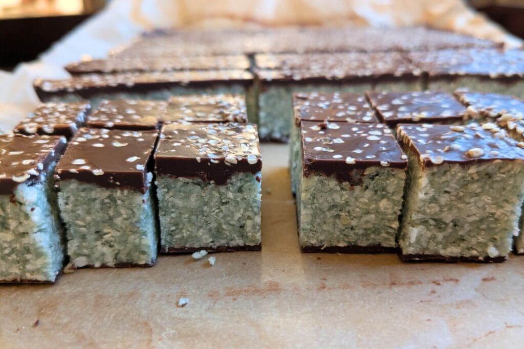 close up shot of no bake chocolate coconut bars with almond flour and green spirulina and peppermint.