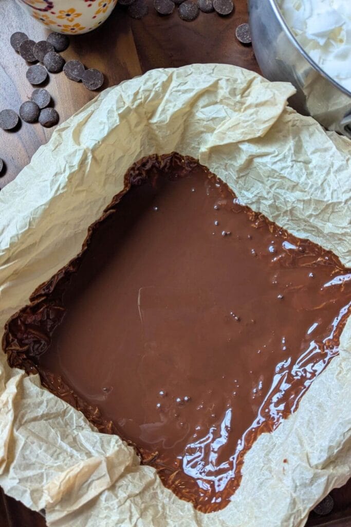 Spreading bottom layer of homemade chocolate magic shell evenly before chilling