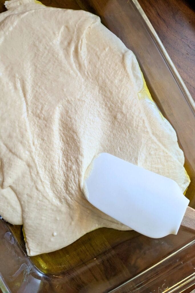 Spread the dough all around and to the edges of the pan.