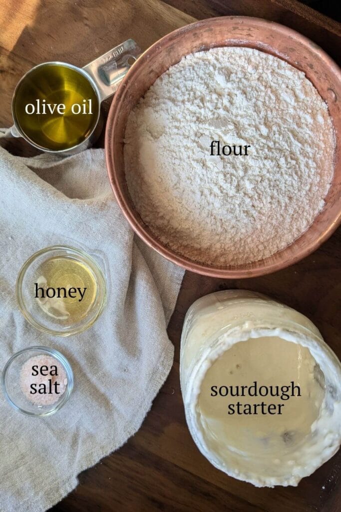 Learn how to make homemade, same-day, no-knead bread with sourdough starter straight from the fridge with these simple ingredients: flour, starter, olive oil, honey and sea salt.