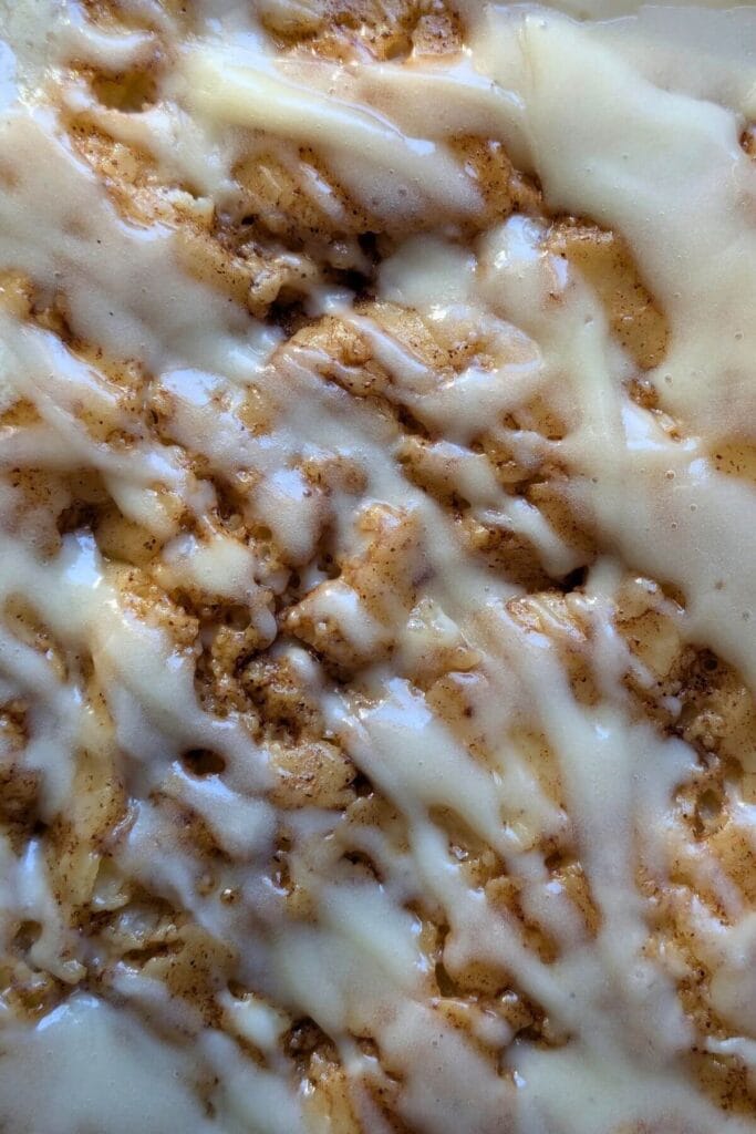 Easy, no knead, same-day sourdough cinnamon roll focaccia drizzled with cream cheese frosting