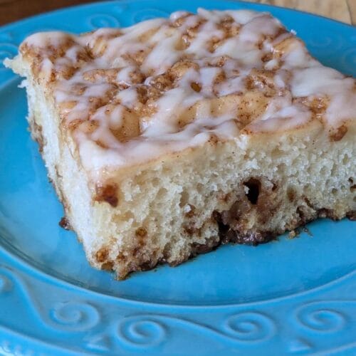 Easy, no knead, same-day sourdough cinnamon roll focaccia setting on a plate with a napkin, ready to eat