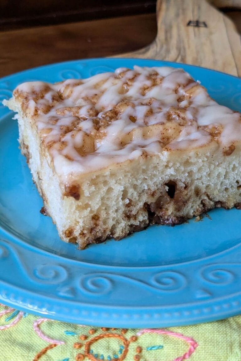 Easy, no knead, same-day sourdough cinnamon roll focaccia setting on a plate with a napkin, ready to eat