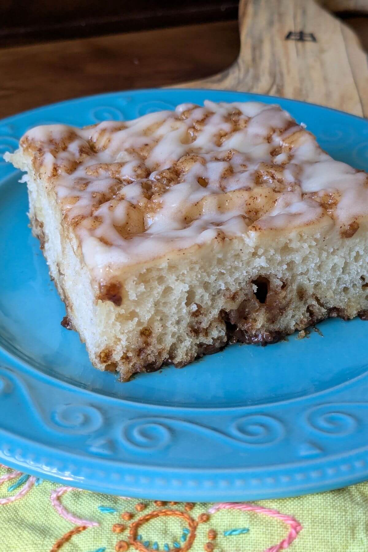 Easy, no knead, same-day sourdough cinnamon roll focaccia setting on a plate with a napkin, ready to eat