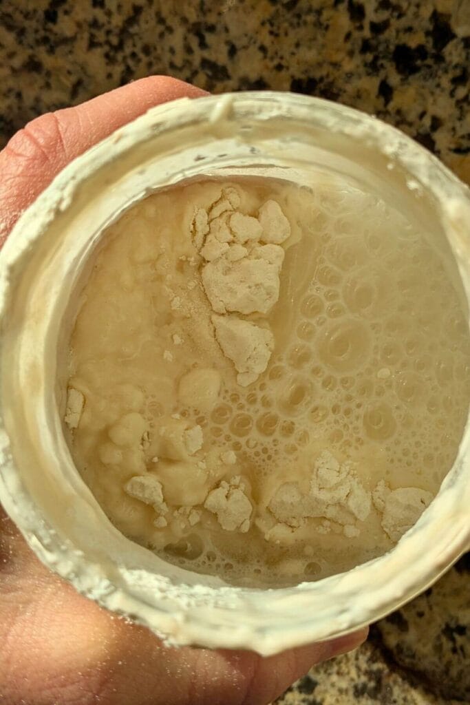 flour and water added to a mason jar because the contents have just been poured out to use in a recipe