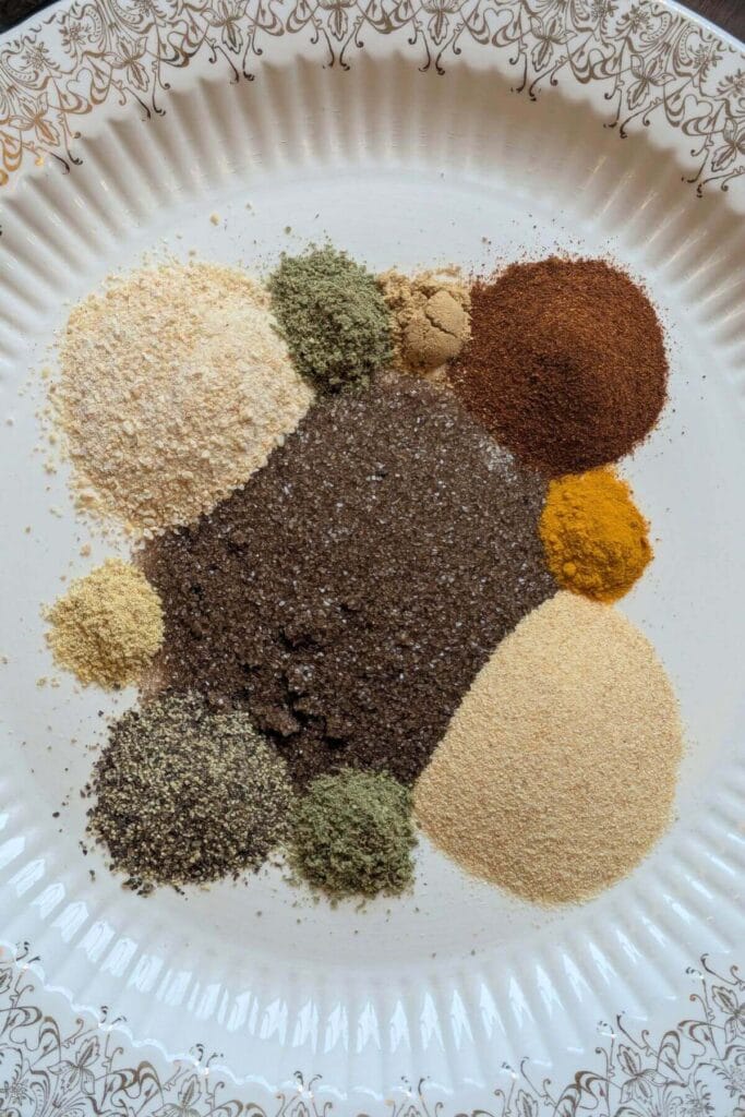 Ingredients for homemade steak seasoning including smoked salt, garlic, herbs and spices